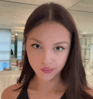 a close up of a woman 's face with a black tank top on