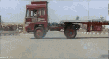 a red truck is driving down a road and the website www.j3.am is visible