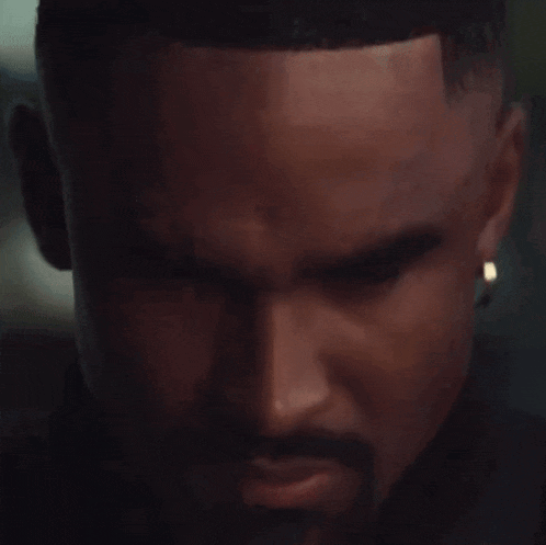 a close up of a man 's face with a beard and earring
