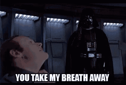 a man is standing next to a statue of darth vader in a locker room .