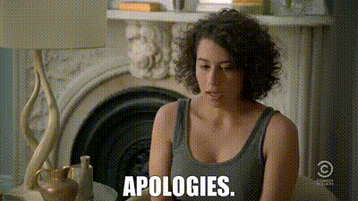 a woman is sitting in front of a fireplace in a living room and saying `` apologies '' .