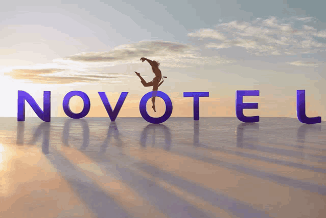 a person is jumping in the air in front of the word novotel