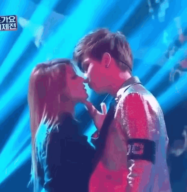 a man and a woman are kissing each other on a stage .