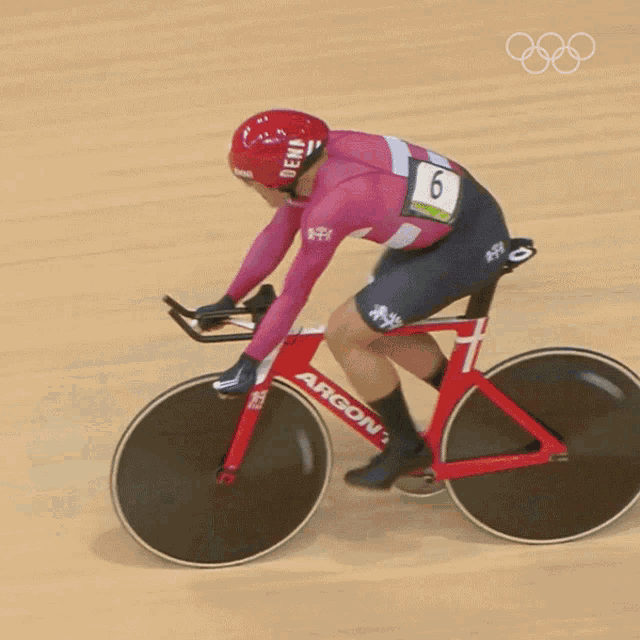 a person riding a red argon bike with the number 7 on the front