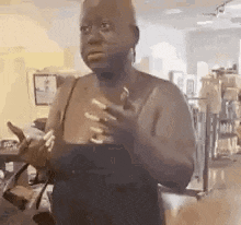 a woman without a shirt is standing in a room holding a bottle of wine .