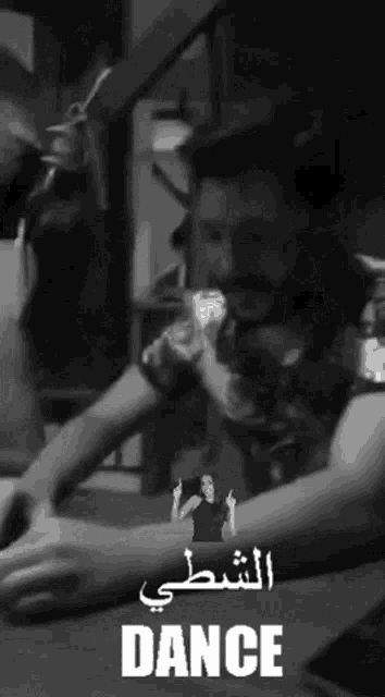 a black and white photo of a man sitting at a table with the word dance in white letters