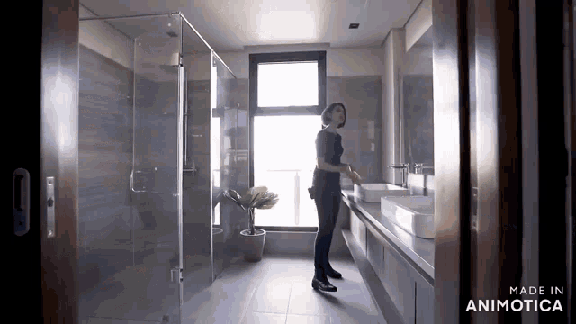 a woman is standing in a bathroom with the words made in animotica on the bottom right