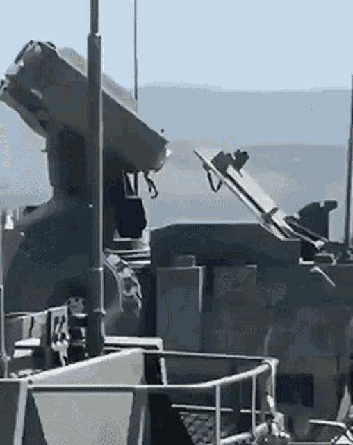 a military vehicle is parked on the side of the road with its hood up .