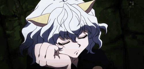 a girl with white hair and cat ears is sleeping with her eyes closed and her hand on her face .