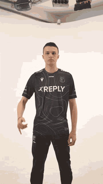 a man wearing a black shirt that says reply