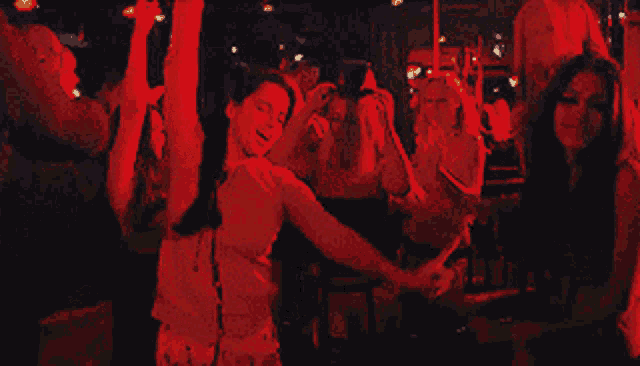 a group of people are dancing in a dark room