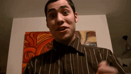 a man in a striped shirt is making a face