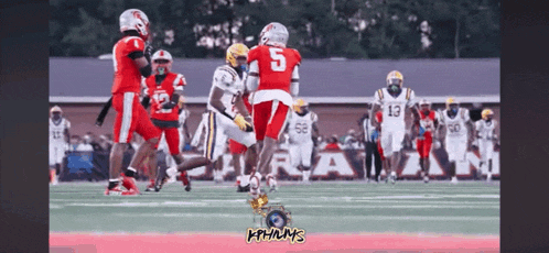 a football player with the number 5 on his jersey is being tackled by another player