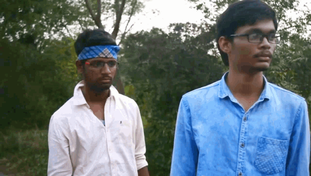 two men standing next to each other one wearing glasses