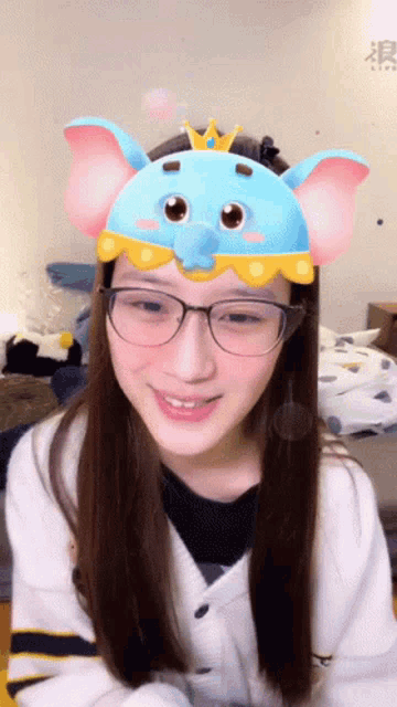 a girl wearing glasses and a blue elephant mask on her head