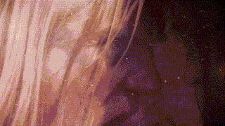 a close up of a woman 's hair with a purple background