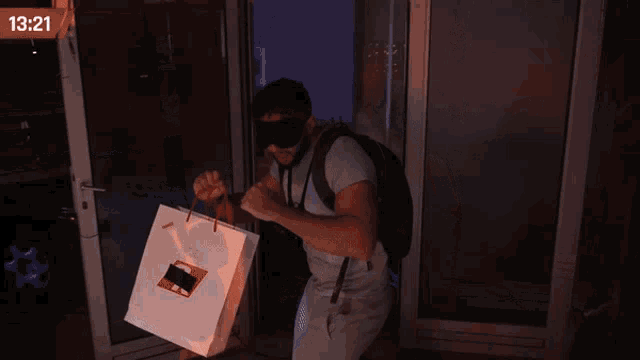 a man wearing a mask is holding a white bag with the time 1319
