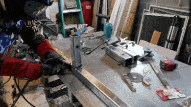 a man wearing a shirt that says ' liberty ' on it is welding a piece of metal