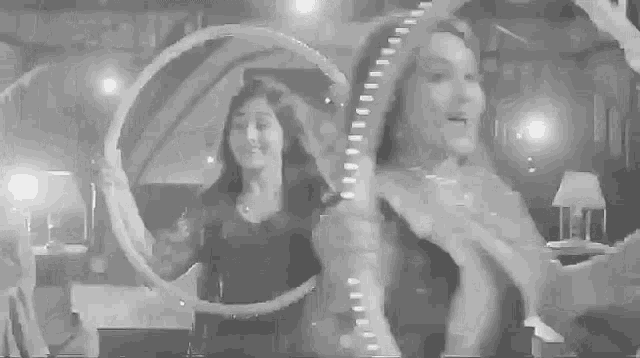 a group of women are dancing together in a room in a black and white photo .