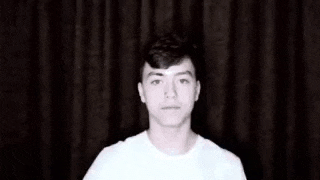 a young man is holding a piece of paper with russian writing on it