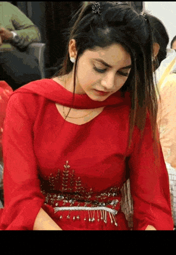 a woman in a red dress is sitting down with her eyes closed