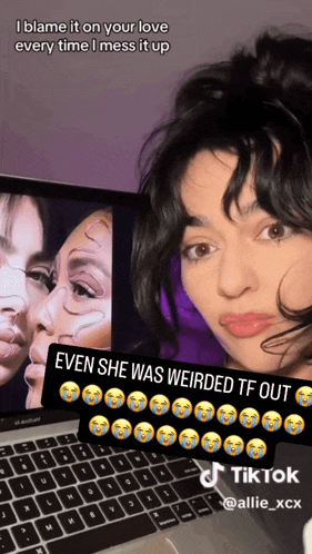 a woman is sitting in front of a laptop with a caption that says i blame it on your love