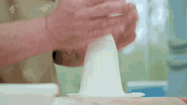 a close up of a person 's hands making a ball of dough with the channel 4 logo above them