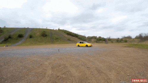 a yellow car is driving down a dirt road with the words thinkjules written on the bottom