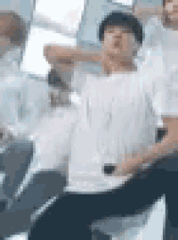 a man in a white shirt is sitting in a chair with his legs crossed .