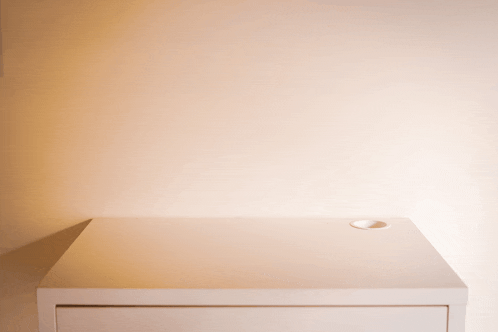 a white shelf has a small hole in the middle of it