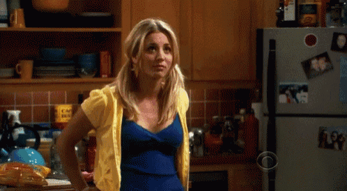 a woman in a kitchen with a cbs logo on the refrigerator door