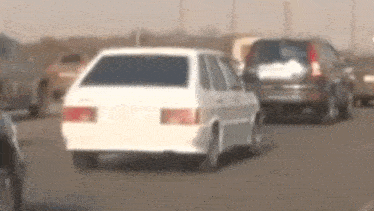 a white car is driving down a highway next to other cars