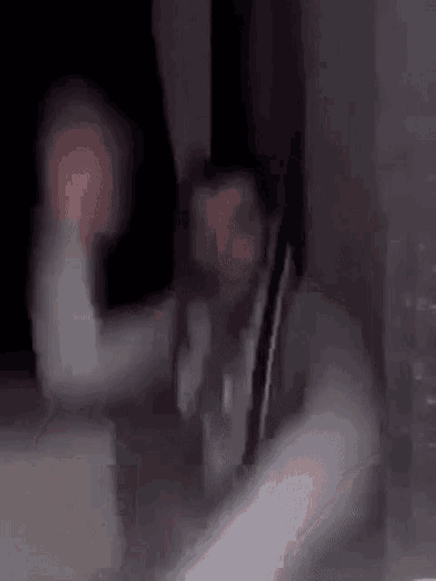 a man is standing in a dark room with his arms outstretched .