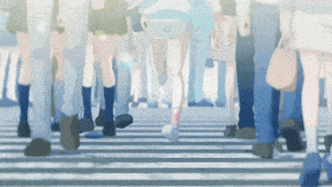 a crowd of people walking across a crosswalk in a blurry photo