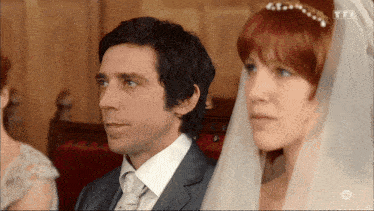 a man in a suit and tie stands next to a woman in a veil with tft written on the bottom right