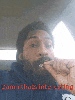 a man with a beard is smoking a cigarette and the caption damn thats interesting