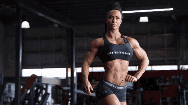 a woman in a gym wearing a sports clothing top