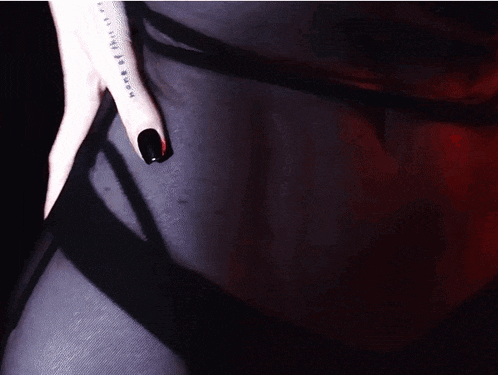 a woman with black nails has a tattoo on her wrist that says " x "