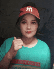 a woman wearing a red hat with the letter m on it gives a thumbs up