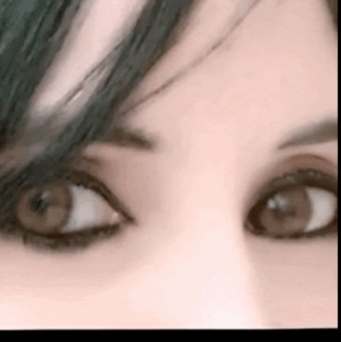 a close up of a woman 's eyes with dark eye shadow .