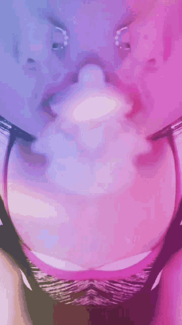 a close up of a woman 's face with a purple and blue background