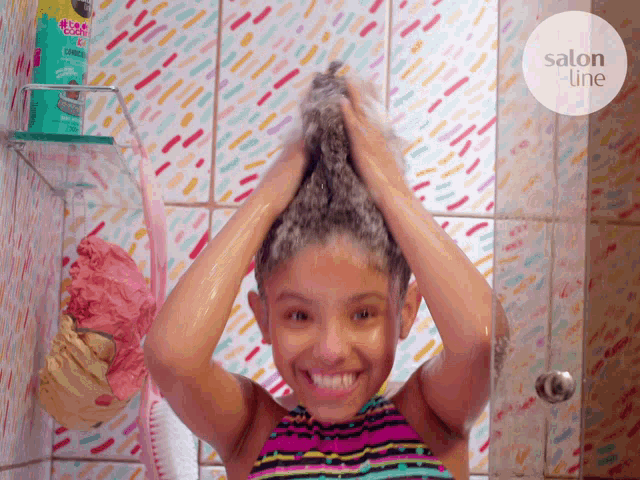 a little girl washing her hair in a shower with a salon title sticker