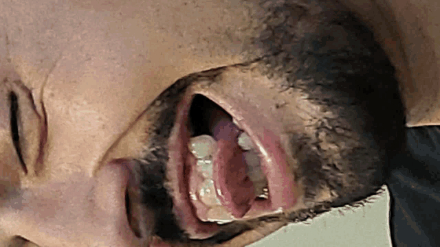 a man with a beard has his mouth open and his tongue sticking out