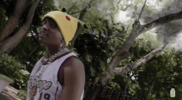 a young man wearing a yellow beanie and a lakers jersey