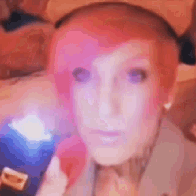 a close up of a person 's face with pink hair .