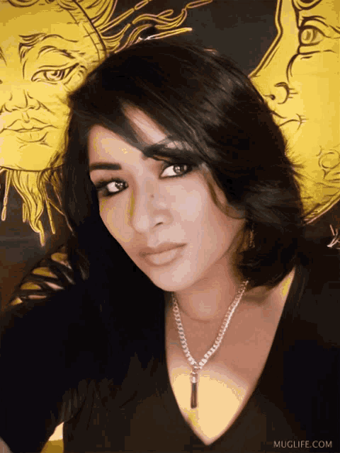 a woman wearing a black shirt and a necklace with muglife.com written on the bottom of the photo