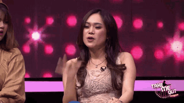 a woman sitting in front of a take me out sign
