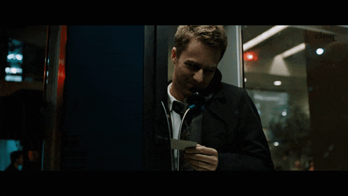 a man in a suit and tie talks on a cell phone