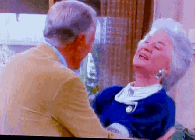 a man and a woman are dancing in a room