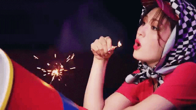 a woman is blowing bubbles with a lit match .